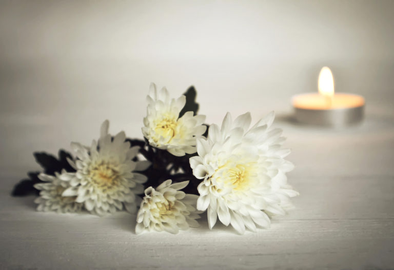 muistotilaisuus kynttilä ja kukat